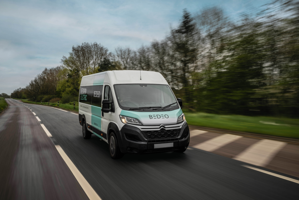 A white large van driving on a dual carriageway